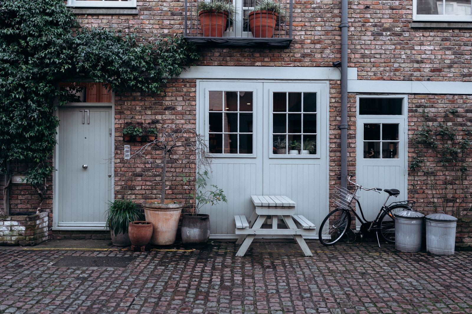 Brick courtyard with a vintage bicycle and climbing greenery